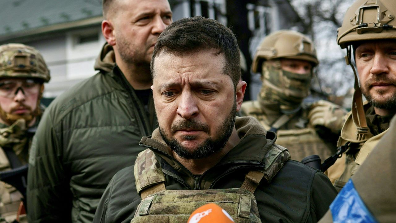 TOPSHOT - Ukrainian President Volodymyr Zelensky (C) speaks to media in the town of Bucha, northwest of the Ukrainian capital Kyiv, on April 4, 2022. - Ukraine's President Volodymyr Zelensky said on April 3, 2022 the Russian leadership was responsible for civilian killings in Bucha, outside Kyiv, where bodies were found lying in the street after the town was retaken by the Ukrainian army. (Photo by RONALDO SCHEMIDT / AFP) (Photo by RONALDO SCHEMIDT/AFP via Getty Images)