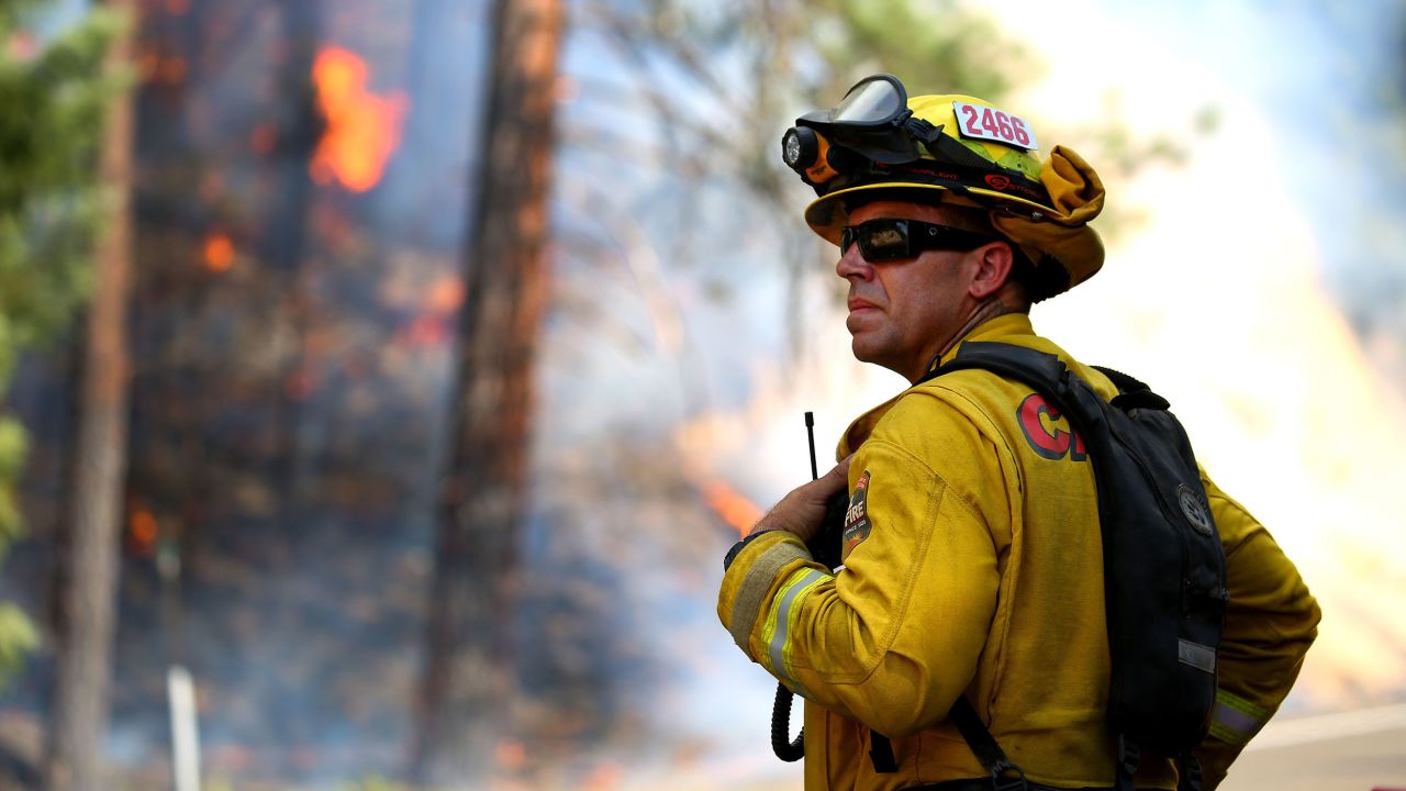 A firefighter monitors fire movement as it crosses Highway 299 in California.