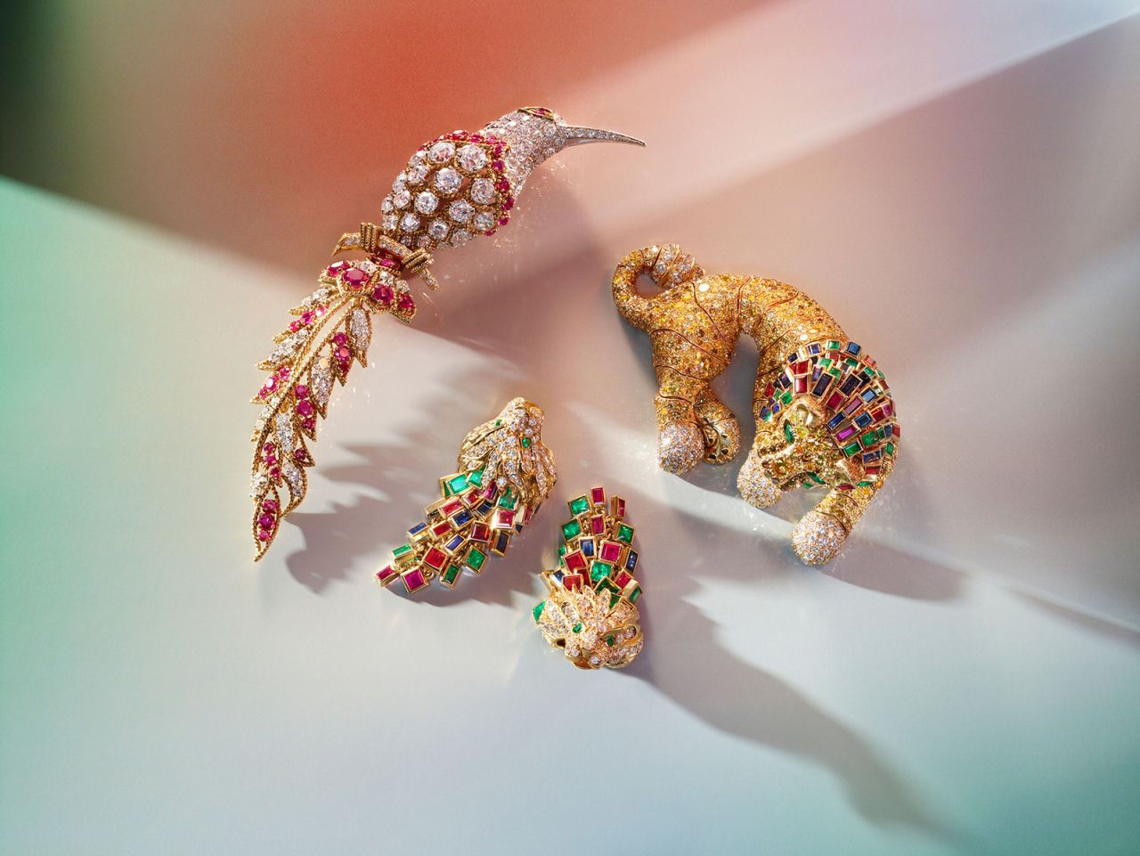 A Van Cleef & Arpels ruby and diamond "Bird of Paradise" brooch, a René Boivin multi-gem lion brooch and a pair of unsigned lionhead earrings.