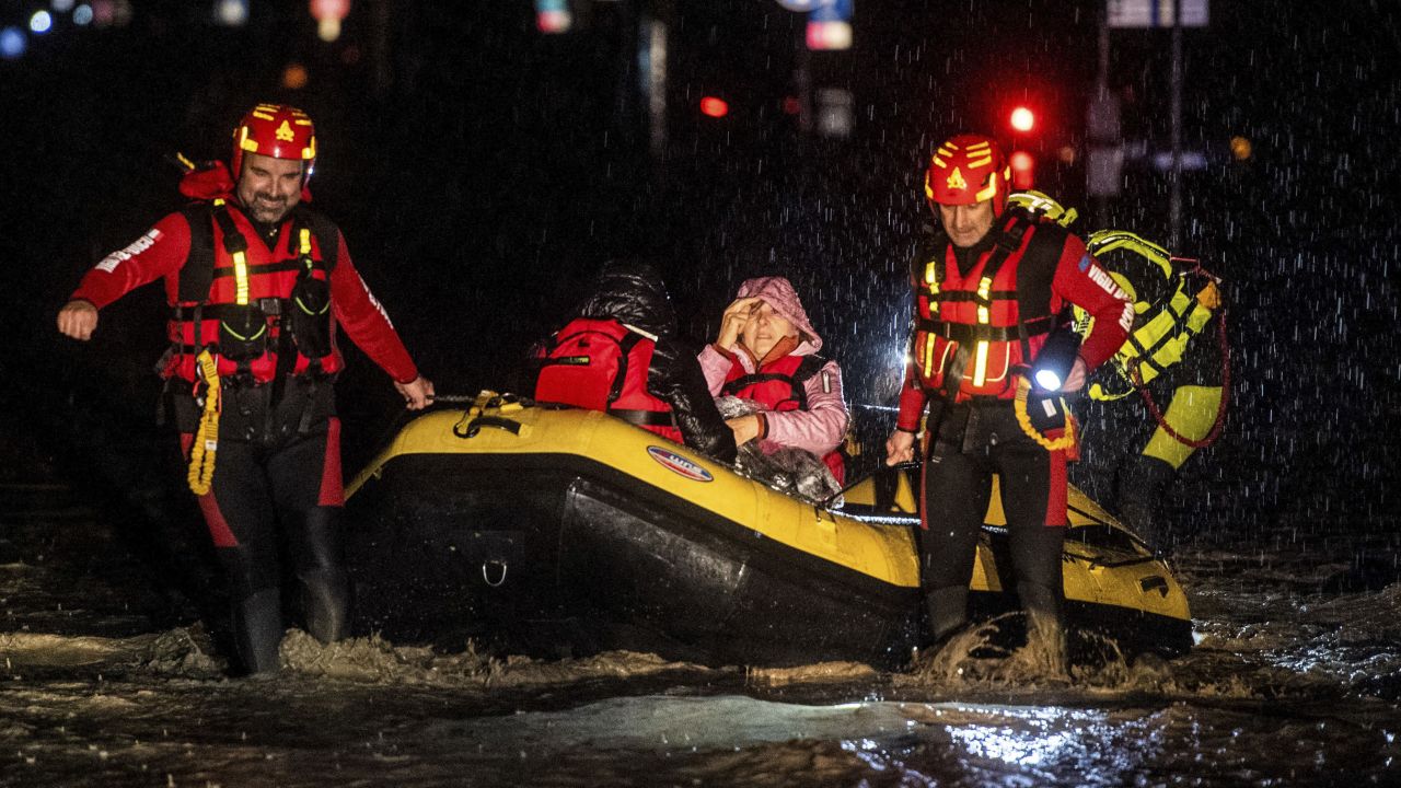 Firemen and civil protection rescuers evacuate a woman with an inflatable boat in the city of Forli in Italy's northern Emilia-Romagna region on Wednesday following severe flooding. 