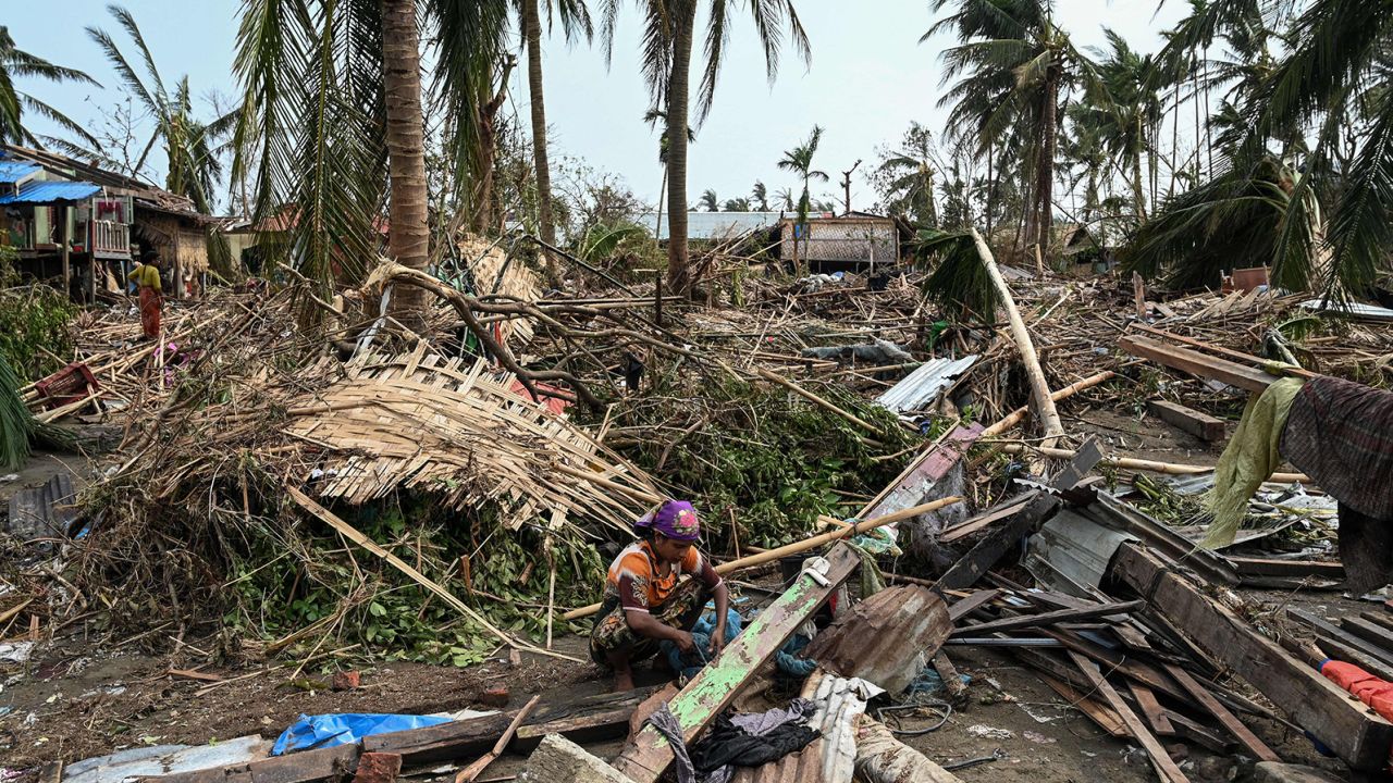 A woman sits in her destroyed house at Basara refugee camp in Sittwe on May 16, after Cyclone Mocha made landfall.