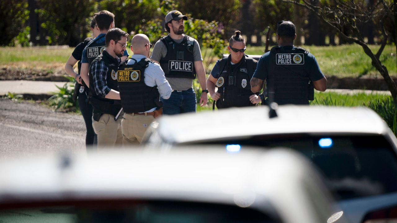 Metro Nashville Police and FBI personnel work near a house in the city after the March 27 mass shooting.
