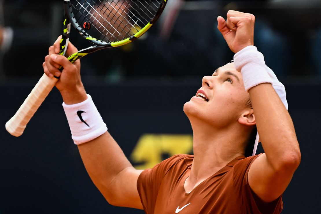 Holger Rune celebrates after defeating Novak Djokovic.