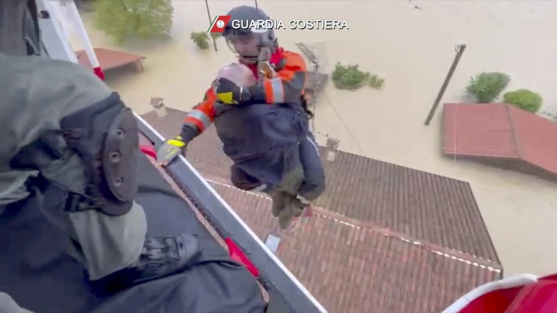 This photo provided by the Italian Coast guard shows rescuers saving a man from the roof of a flooded house, in the area of the town of Faenza.