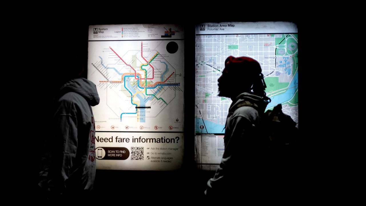 People walk past the metro maps at the Potomac Avenue Metro Station in Washington, DC, on March 31.