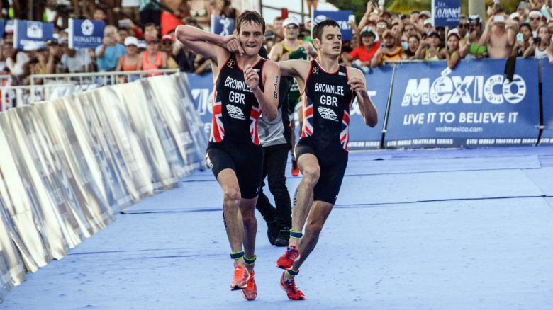 TOPSHOT - British athlete Alistair Brownlee (L) helps his brother Jonathan Brownlee (R) before crossing the line in second and third place during the ITU World Triathlon Championships 2016 in Cozumel, Quintana Roo, Mexico on September 18, 2016. / AFP / ELIZABETH RUIZ        (Photo credit should read ELIZABETH RUIZ/AFP via Getty Images)