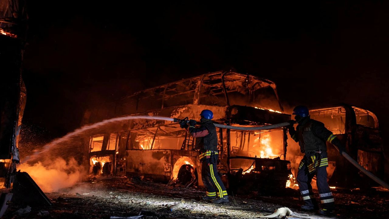 Firefighters repair the damage at a vehicle parking area after Russian missiles struck Kyiv on Tuesday. The White House rebuffed Moscow's claims that the attack hit a Patriot missile defense system.