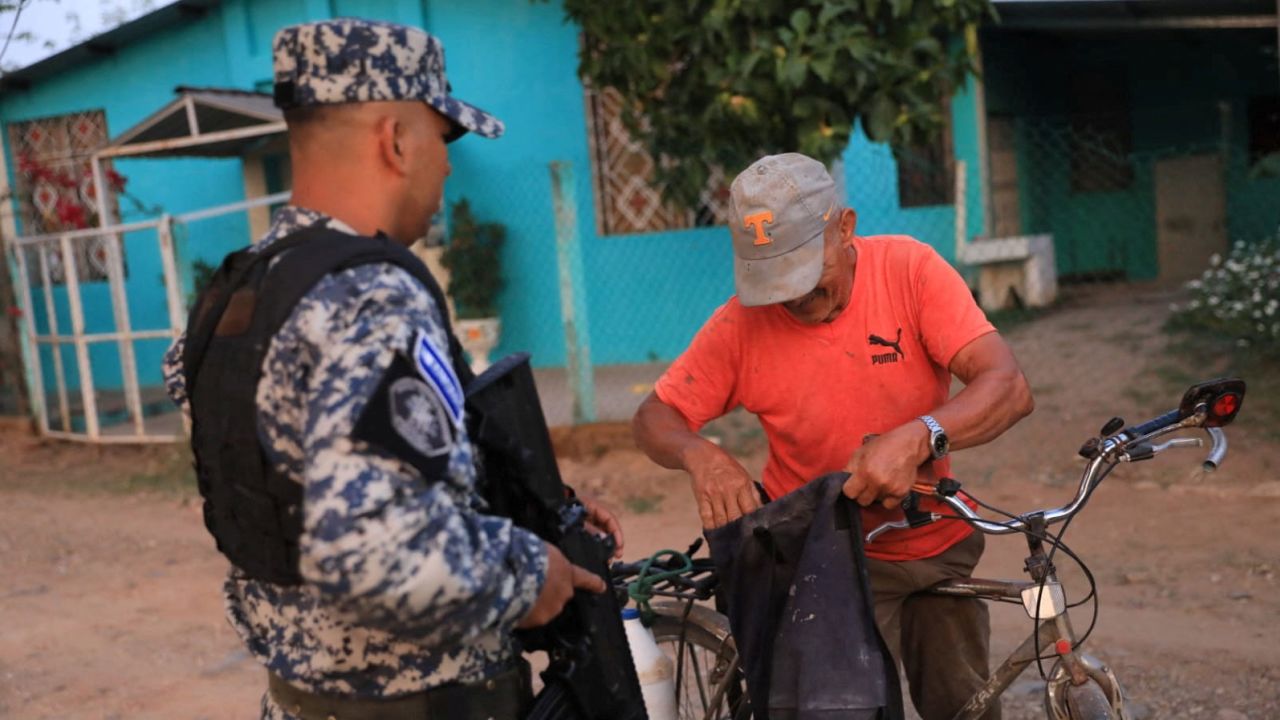 A police officer stops a man in Nueva Concepcion after Bukele announced the deployment of security forces to the area in May 17, 2023.