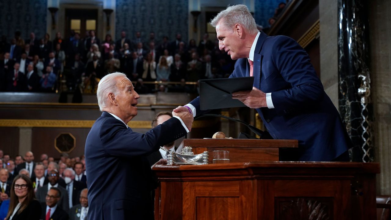 President Joe Biden shakes hands as he presents a copy of his speech to House Speaker Kevin McCarthy before he delivers his State of the Union address to a joint session of Congress, on February 7 in the House Chamber of the Capitol in Washington, DC.