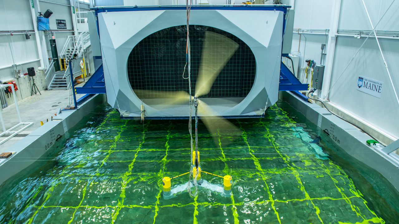 A floating offshore wind model turns in front of a massive wall of fans at the lab, as the indoor pool simulates waves. The wall of fans is designed to replicate hurricane-force winds.