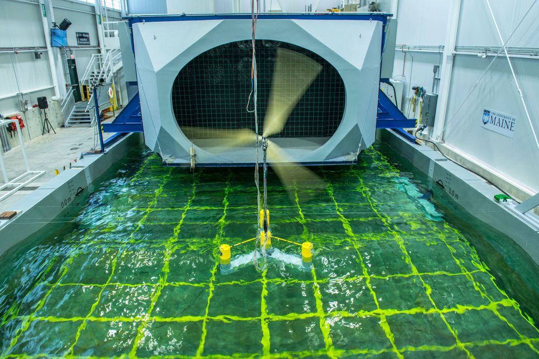 A floating offshore wind model turns in front of a massive wall of fans at the lab, as the indoor pool simulates waves. The wall of fans is designed to replicate hurricane-force winds.