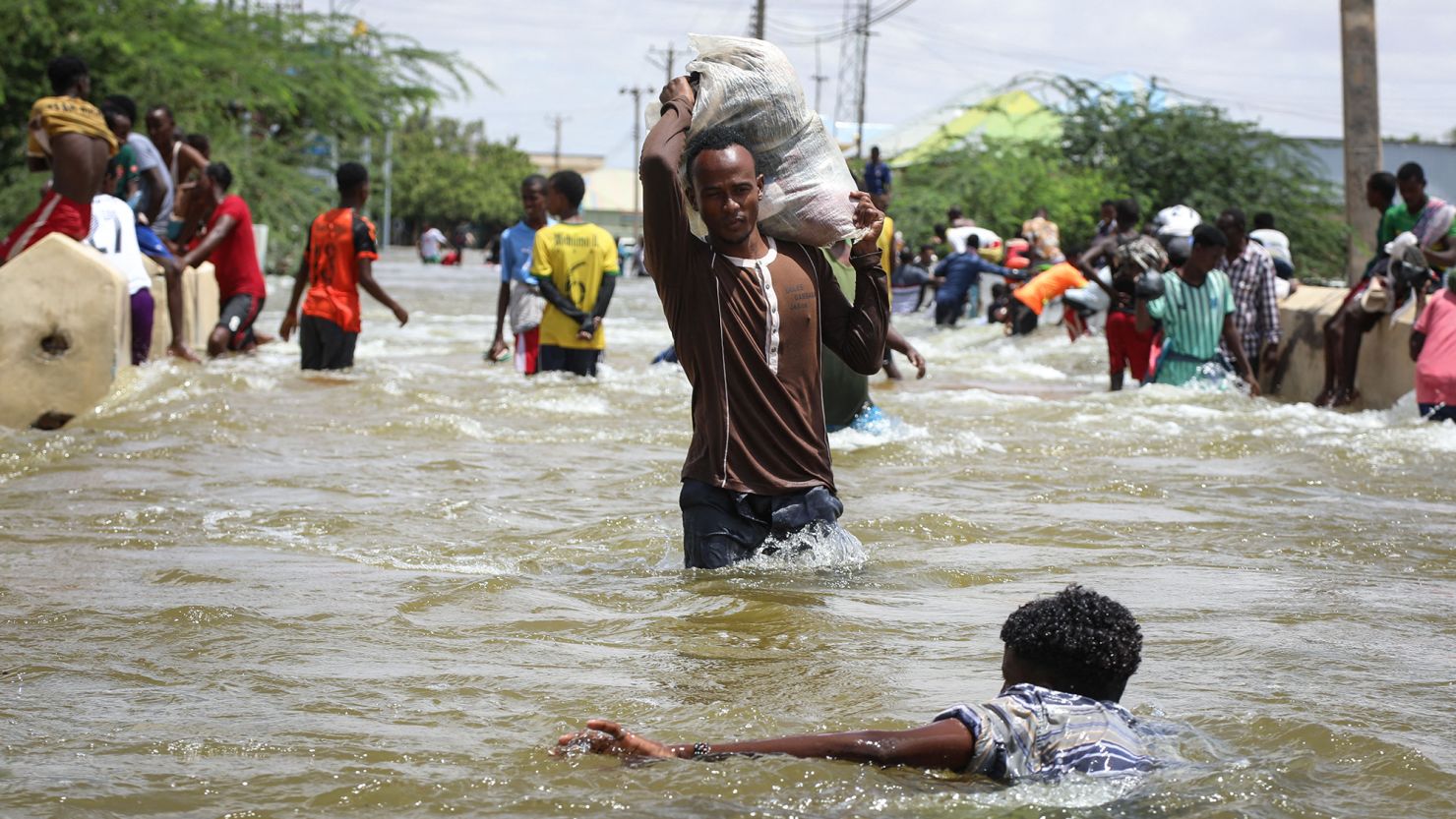 A man carries a sack through floodwater in Beledweyne, central Somalia. Flash flooding in central Somalia has killed 22 people and affected over 450,000, the UN's humanitarian agency OCHA said. 