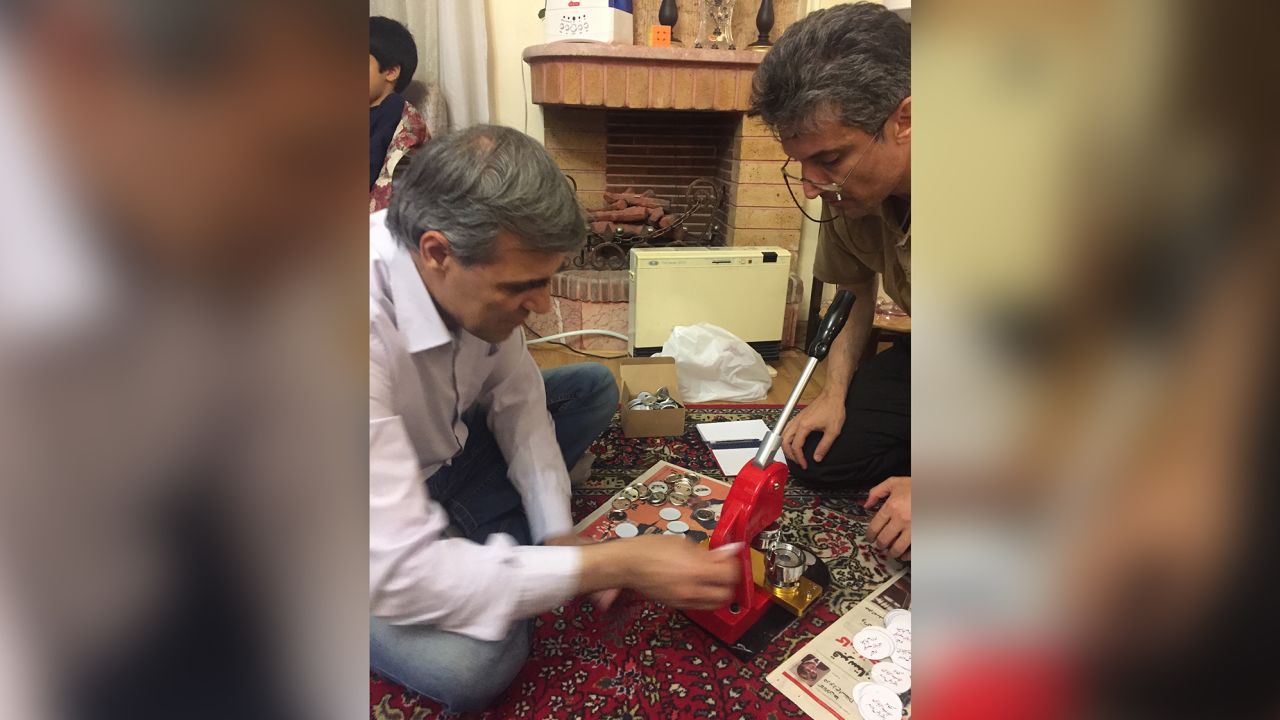 Reza Khandan and Farhad Meysami with the their hand held button-making machine in Iran, 2018.