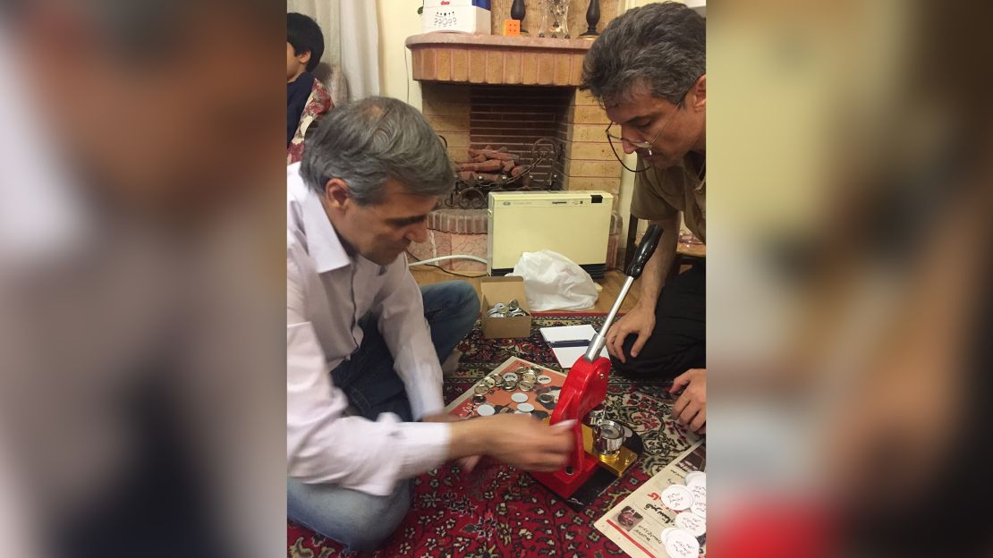 Reza Khandan and Farhad Meysami with the their hand held button-making machine in Iran, 2018.