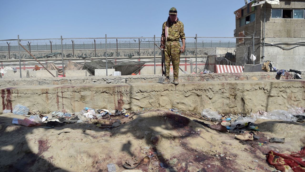 A Taliban fighter stands guard at the site of the twin suicide bombing, which killed scores of people at Kabul airport on August 26, 2021.