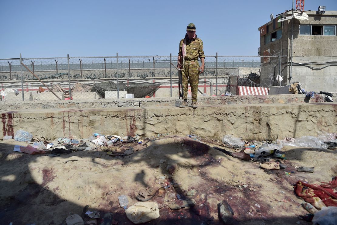 A Taliban fighter stands guard at the site of the twin suicide bombing, which killed scores of people at Kabul airport on August 26, 2021.