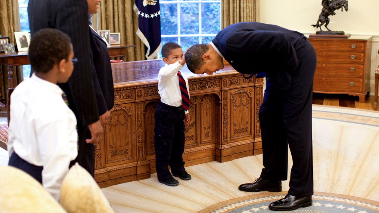 An undated handout photo of Jacob Philadelphia, 5, center, the son of a White House staff member, touches President Barack Obama's hair to see if it feels like his, in the Oval Office of the White House in Washington. The photo of Jacob has struck so many White House aides and visitors that by popular demand it stays put in the West Wing while others come and go. (Pete Souza/The White House via The New York Times) -- EDITORIAL USE ONLY