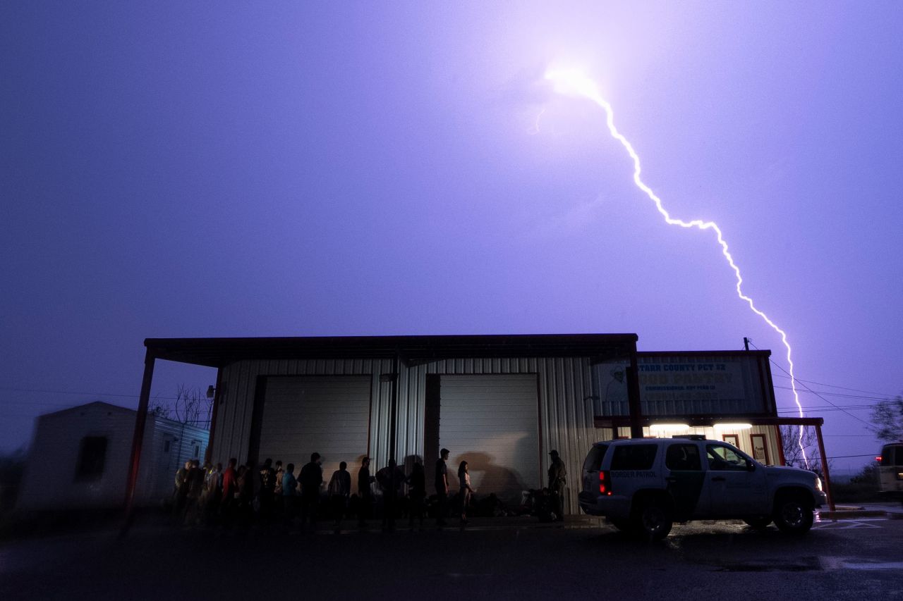 A lightning bolt is seen in the sky as migrants line up for processing in Fronton, Texas, on Saturday, May 13. The migrants had just crossed the US-Mexico border. The expiration of the border restriction policy known as Title 42 has so far brought <a href="https://www.cnn.com/2023/05/14/us/title-42-border-immigration-sunday/index.html" target="_blank">fewer migrant arrivals than expected</a>, but southern border communities still worry about overcrowded facilities for processing and detention.