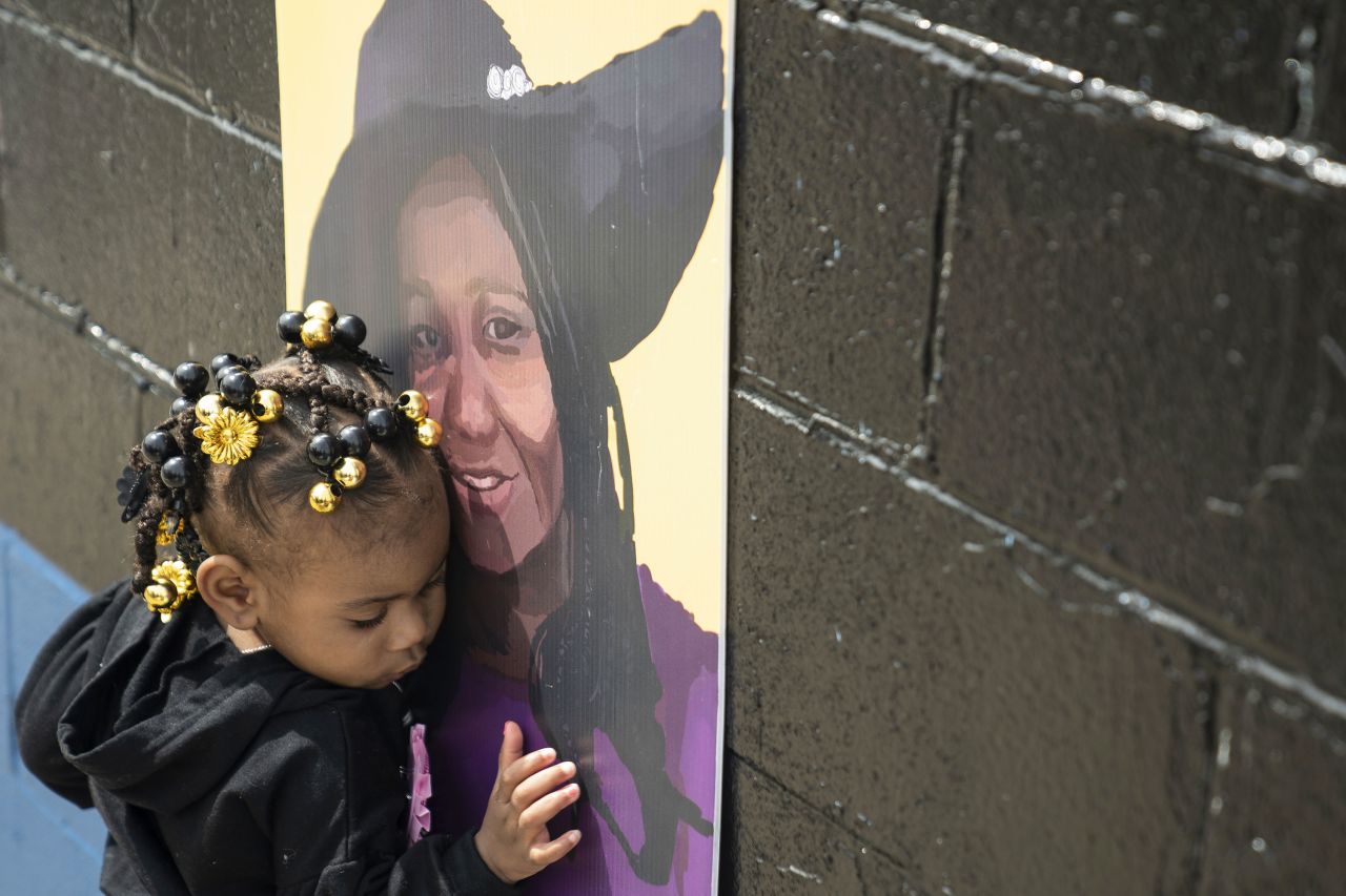 Naujaj Buchanan, 2, nestles close to a portrait of her godmother, Geraldine Talley, on Sunday, May 14, across the street from the Buffalo, New York, supermarket where Talley was killed in a <a href="https://www.cnn.com/2023/05/17/europe/italy-flooding-three-killed-rain-intl/index.html" target="_blank">mass shooting last year</a>.
