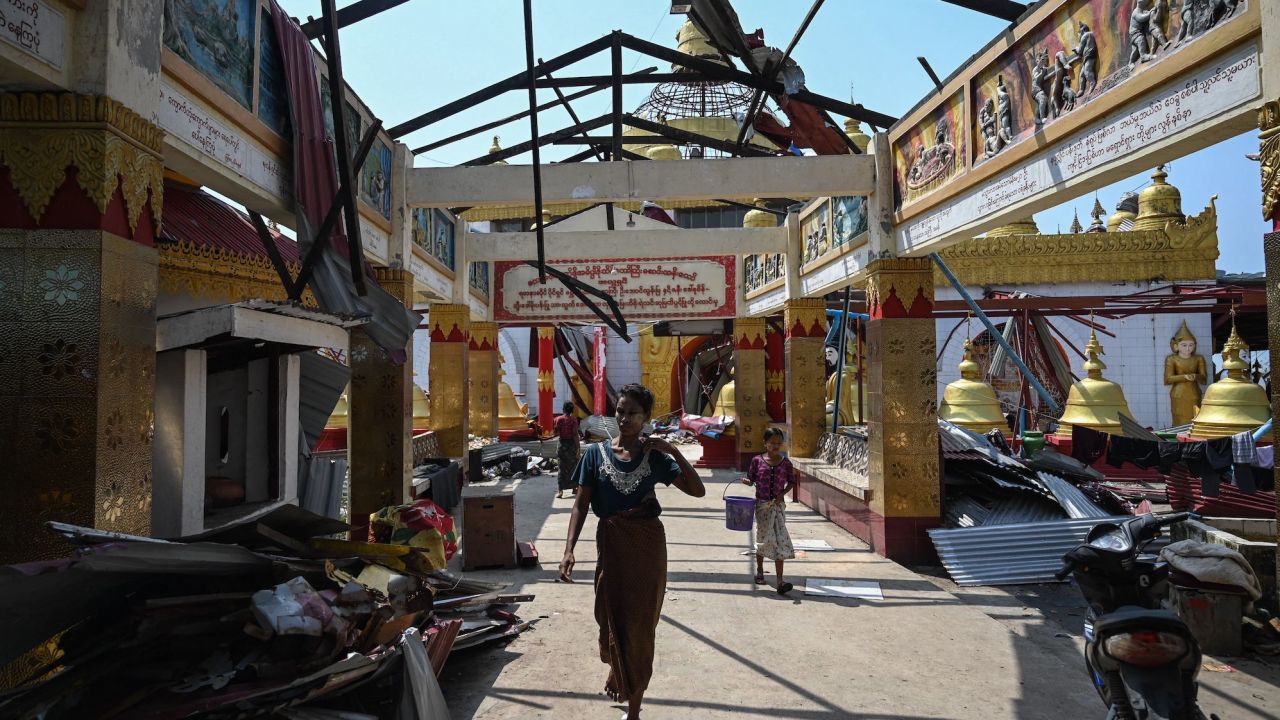 A woman walks through a destroyed monastery in Sittwe on May 17 in the aftermath of Cyclone Mocha's landfall. 