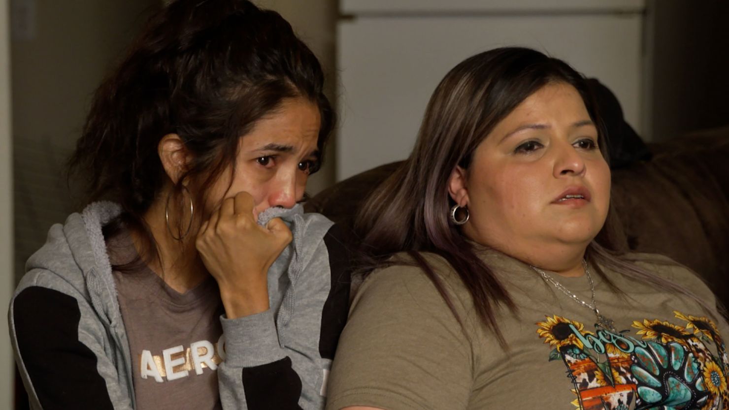Kristina Olivares, left, and Kassandra Chavez tear up as they watch their injured children being transported to the hospital on a school bus after they were freed from the school.