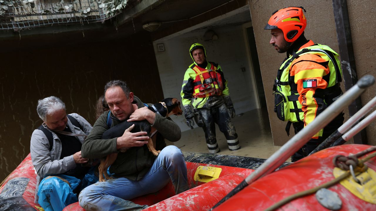 Rescue workers evacuate people and a dog from a flooded house in Faenza on Friday. 