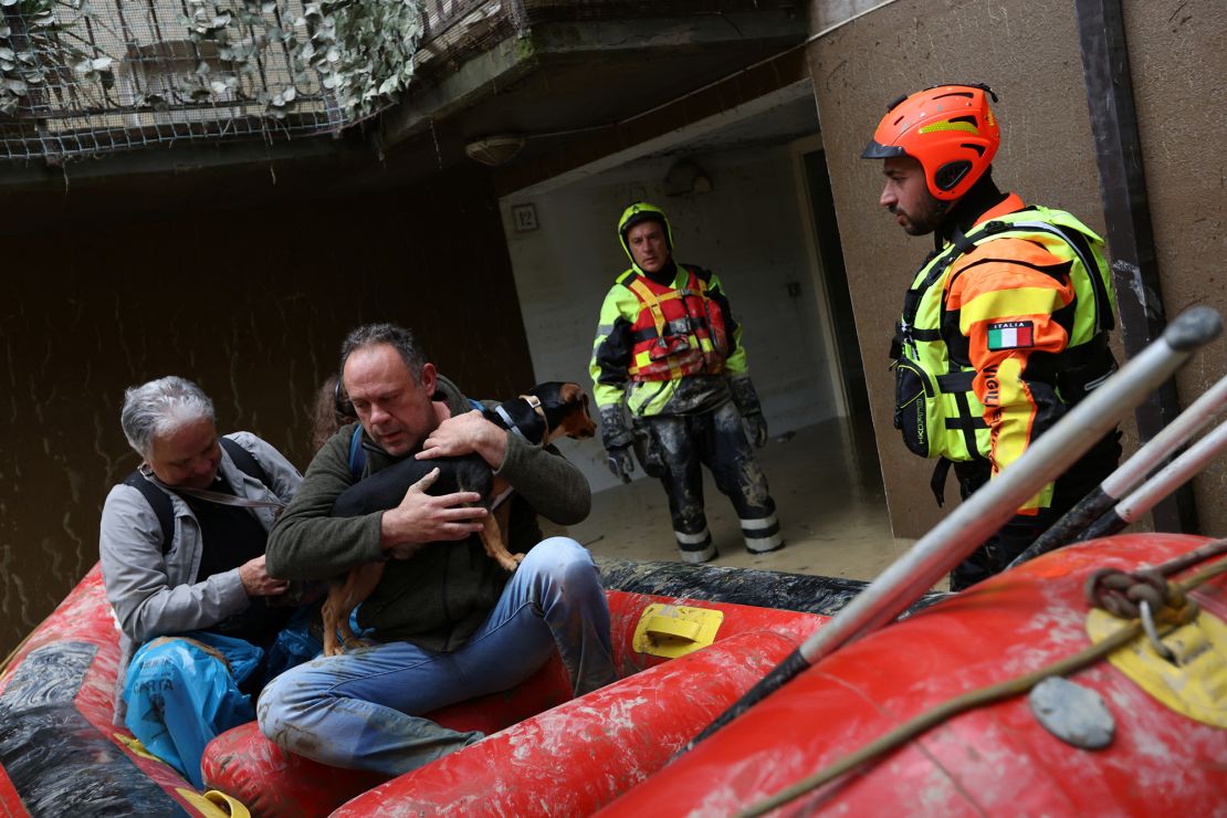Rescue workers evacuate people and a dog from a flooded house in Faenza on Friday. 