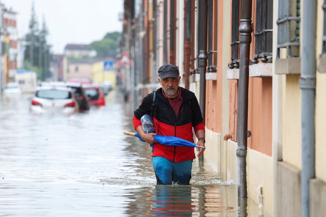 A man wades through floodwaters in the town of Lugo on Friday. Researchers say the devastation is linked to the climate crisis.