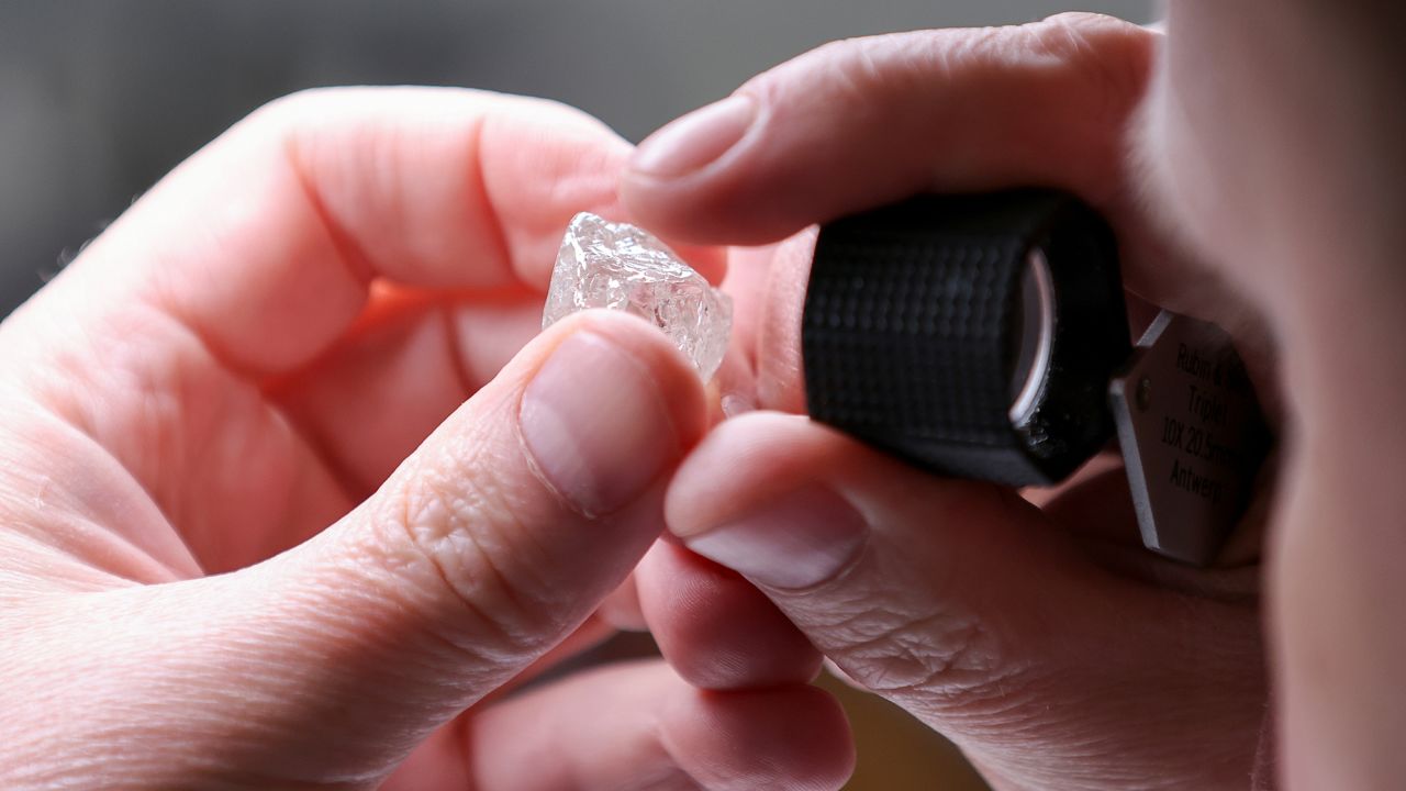 An employee holds a rough diamond at the "Diamonds of Alrosa" factory in Moscow, Russia, in April 2021.
