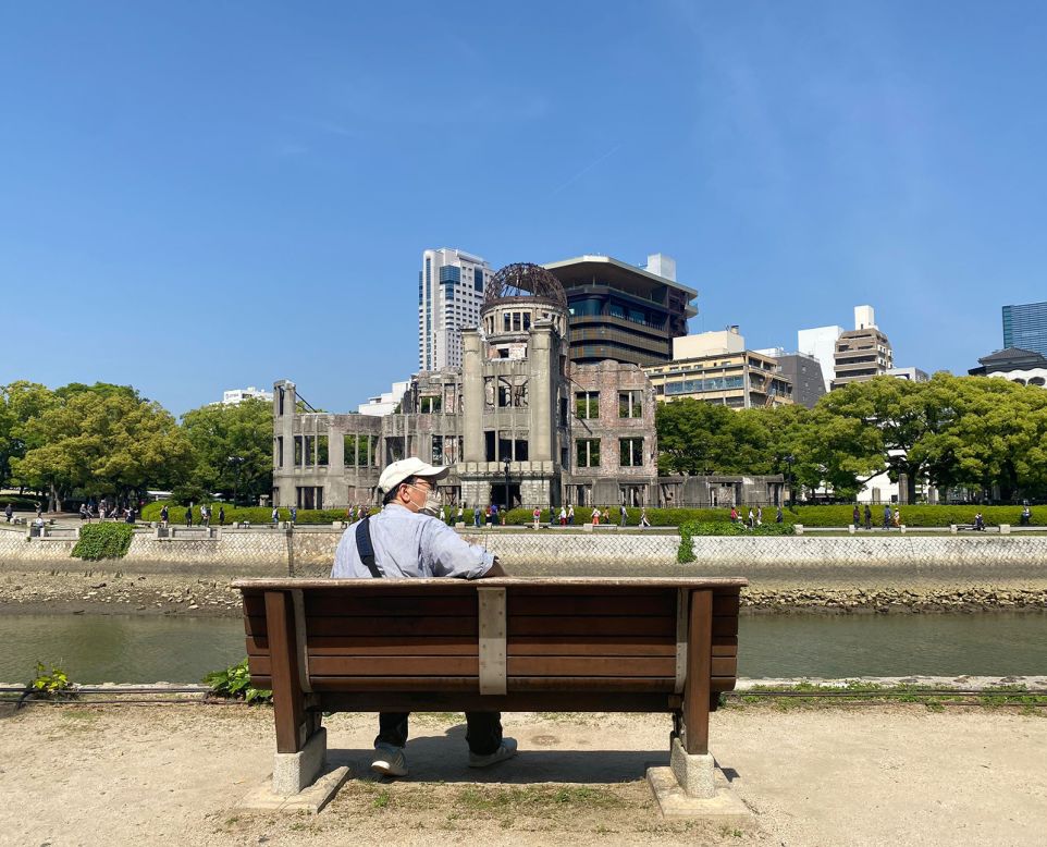 <strong>Genbaku Dome: </strong>A man relaxes alongside the river on a bench overlooking the half-exploded Genbaku Dome. To this day, it's a stark reminder to all who live and visit of the devastating impact of war. 