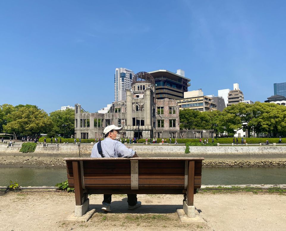<strong>Genbaku Dome: </strong>A man relaxes alongside the river on a bench overlooking the half-exploded Genbaku Dome. To this day, it's a stark reminder to all who live and visit of the devastating impact of war.