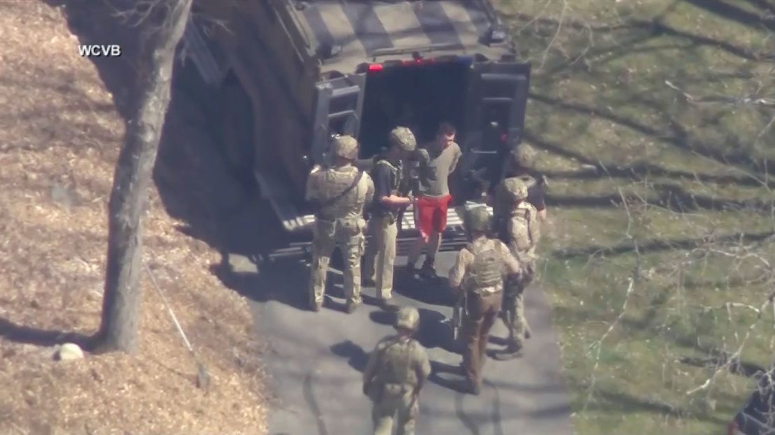 This image made from video provided by WCVB-TV, shows Jack Teixeira, in T-shirt and shorts, being taken into custody by armed tactical agents in April in Dighton, Massachusetts. 