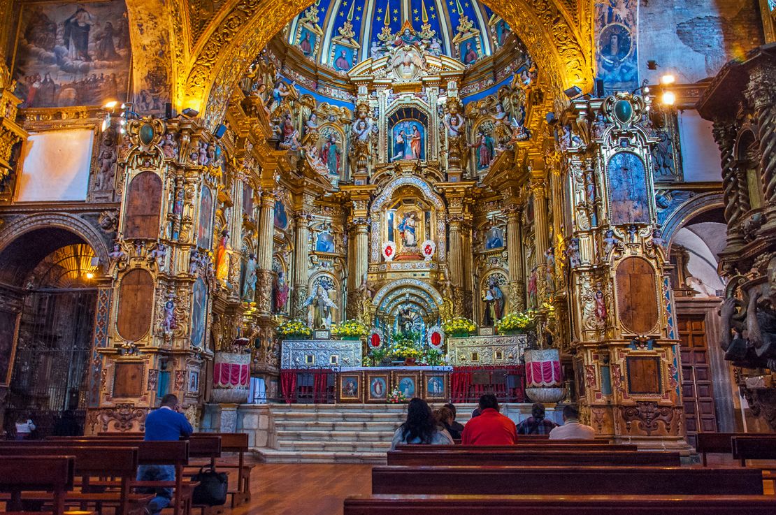 These Andean worshippers are inside the Spanish colonial church of San Francisco in the city center of Quito, Ecuador. This church was built during the Spanish colonial era by Spanish friars. Today, this Catholic Church is still an active parish for the inhabitants of this South American capital city.