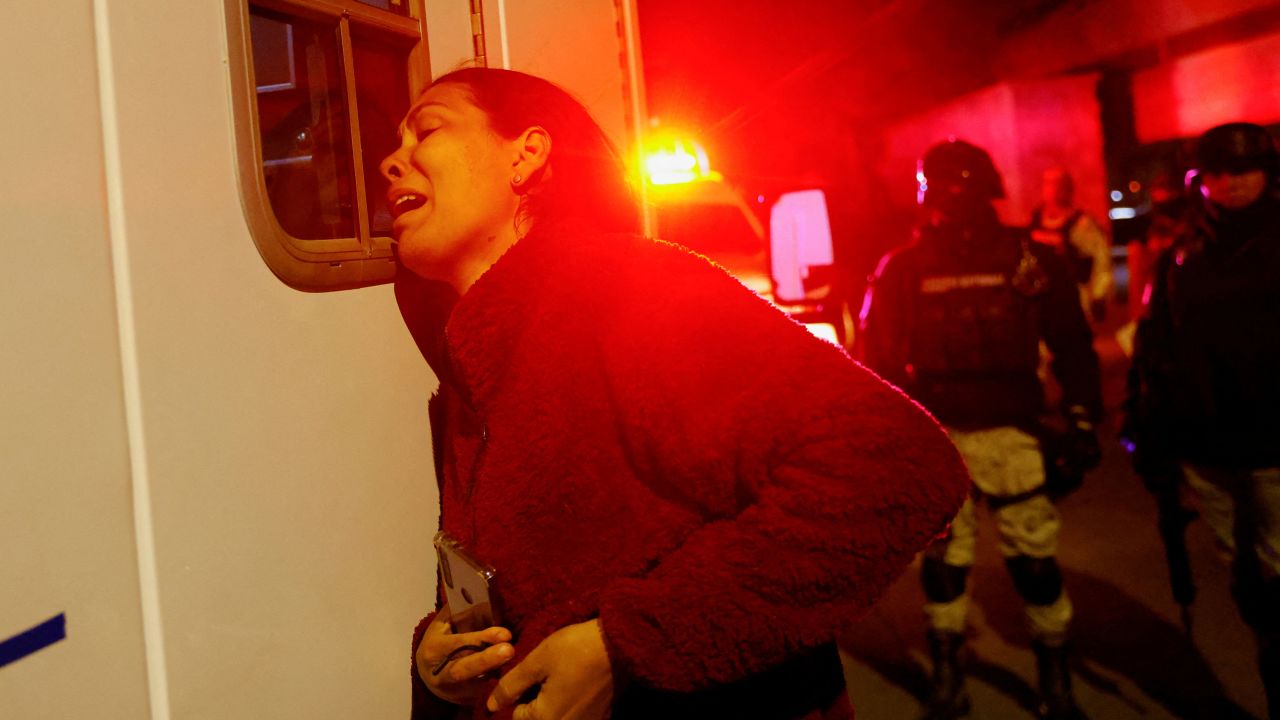 Viangly, a Venezuelan migrant, reacts outside an ambulance while firefighters remove injured migrants, mostly Venezuelans, from a National Migration Institute building during a fire in Ciudad Juarez on March 27, 2023.
