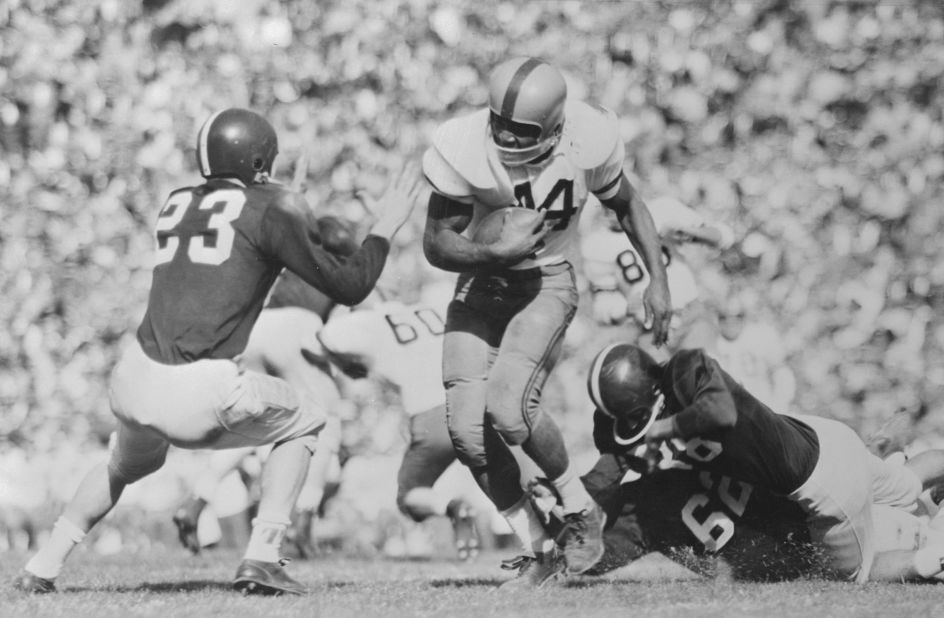 Brown plays football for Syracuse in the 1957 Cotton Bowl. Brown, a bruising fullback, rushed for three touchdowns in the game.