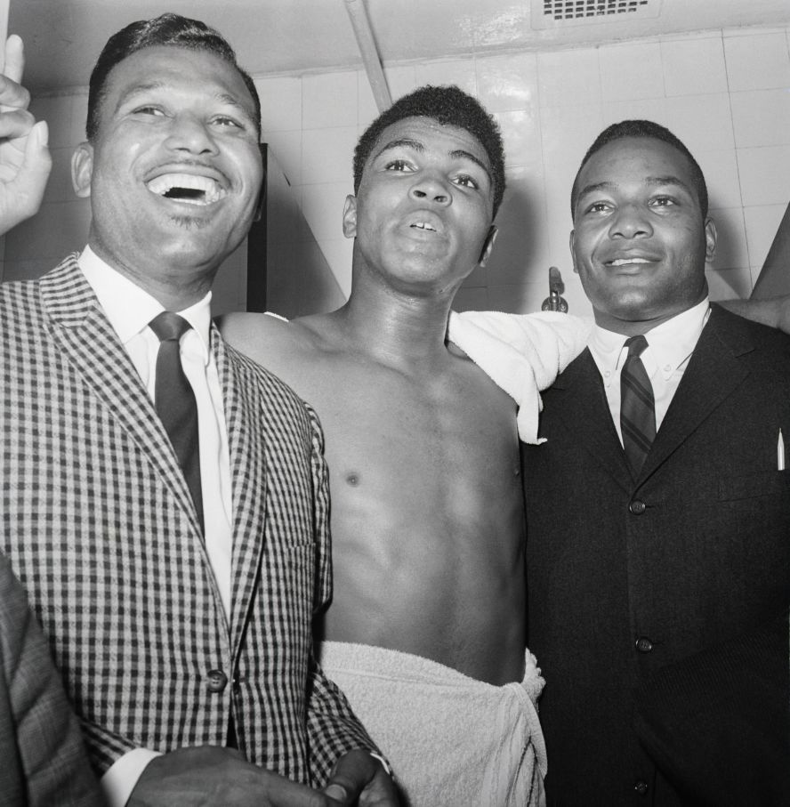 Brown, right, joins boxers Sugar Ray Robinson and Muhammad Ali after Ali won a bout in 1963.