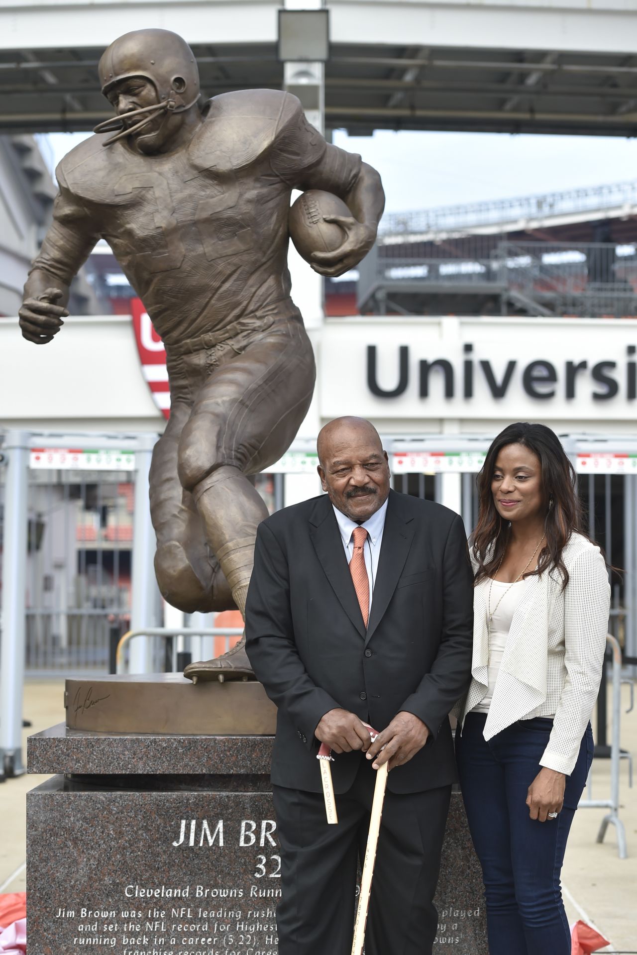 Brown and his wife, Monique, stand in front of his statue outside the Cleveland Browns' stadium in 2016.