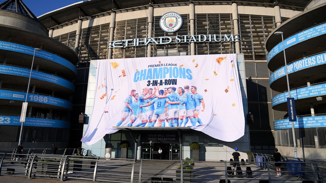 A "Premier League Champions" banner is revealed outside Manchester City's stadium.