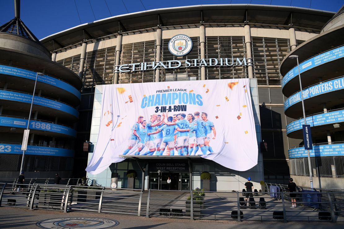 A "Premier League Champions" banner is revealed outside Manchester City's stadium.