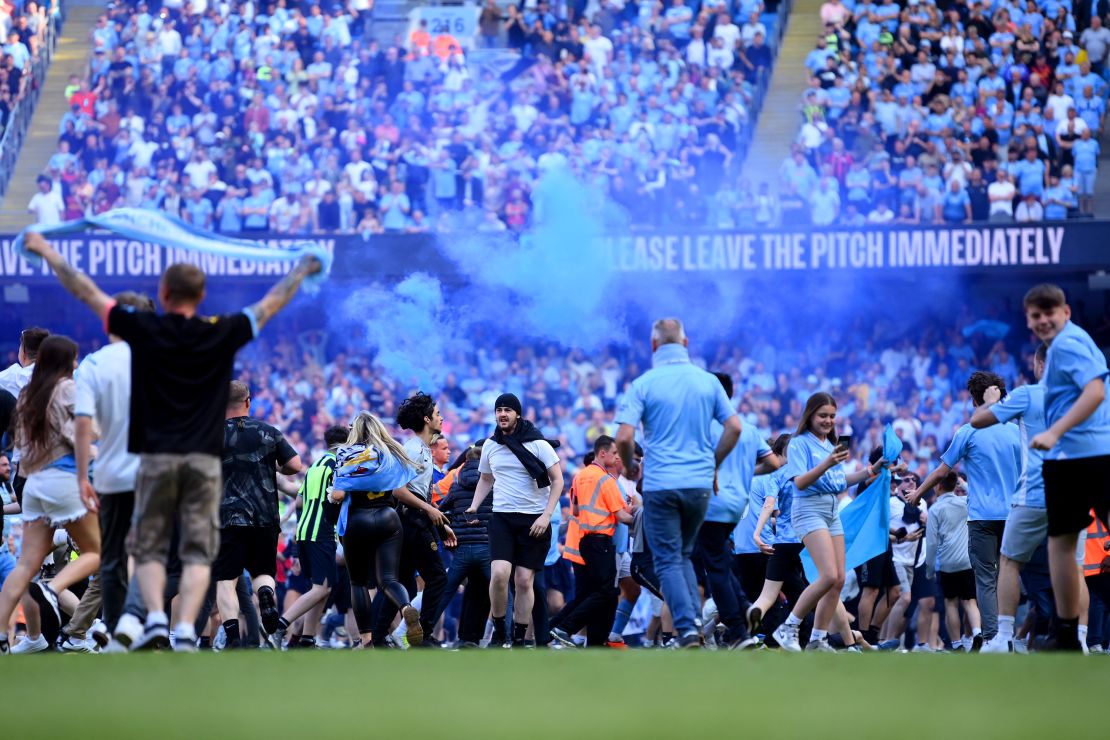 Manchester City fans invade the pitch after Sunday's 1-0 win against Chelsea, teh team's first match since winning the title. 