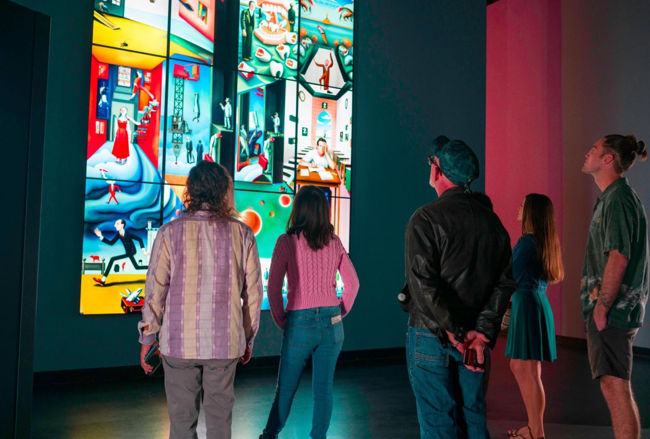 Dalí Museum visitors observe AI-generated images at the "Dream Tapestry" exhibit.