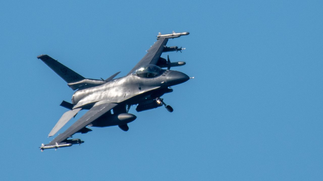Un avión de combate F-16 Fighting Falcon tiene su tren de aterrizaje extendido para aterrizar en el aeródromo militar estadounidense en Spangdahlem, Alemania.