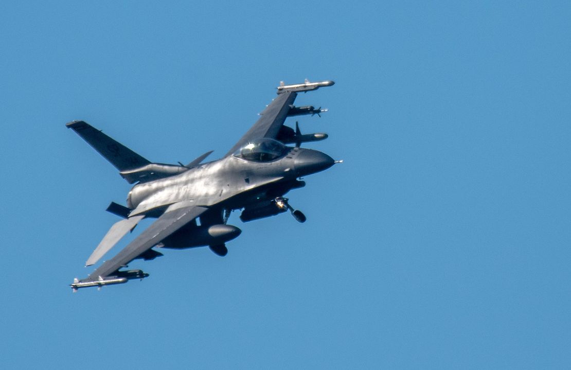 An F-16 Fighting Falcon fighter aircraft has its landing gear extended to land at the US military airfield at Spangdahlem, Germany.