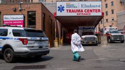 In a photo taken earlier this month, a medical worker walks by an entrance to Elmhurst Hospital Center in Queens, New York. 