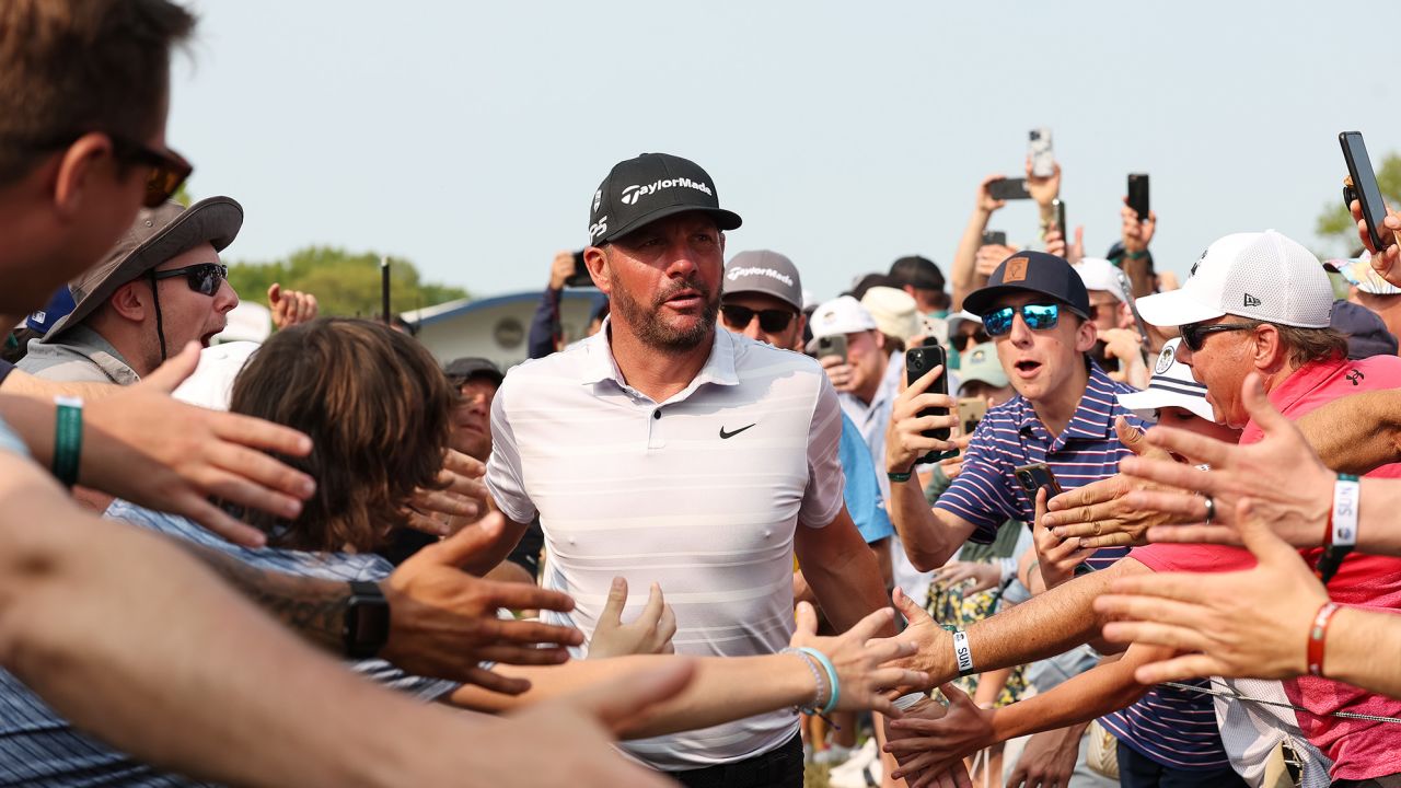 Block celebrates with spectators after hitting a hole-in-one on the 15th hole.