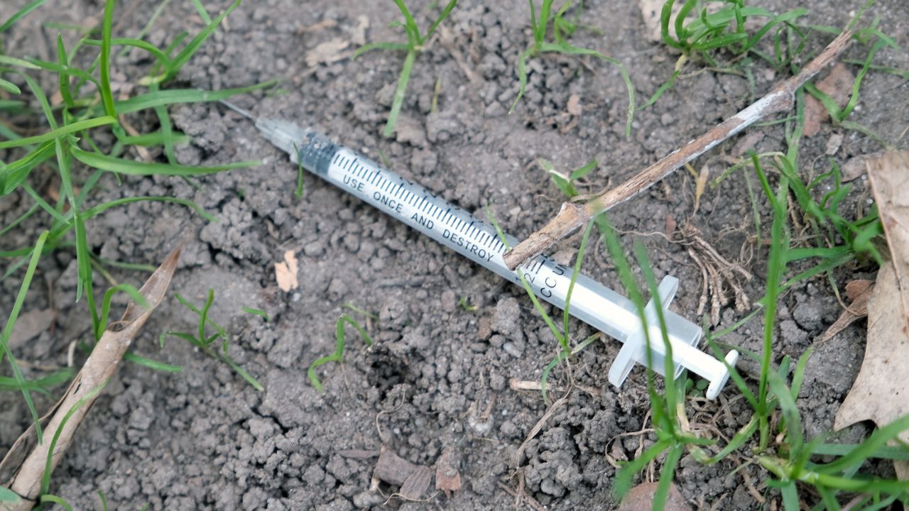 NEW YORK, NEW YORK - OCTOBER 08: A used syringe sits on the ground in a park as local politicians, religious leaders and members of the Harlem community participate in a 'Make Our Streets Safe for Our Children' march and rally on October 08, 2021 in New York City. Harlem, like other parts of Manhattan, has witnessed a surge in crime and drug use in the last year. Parks and other public gathering areas have witnessed a surge in the number of homeless and drug use prompting many residents to demand increased police outreach in the community. (Photo by Spencer Platt/Getty Images)