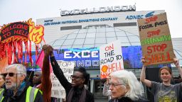 People hold signs as protesters from Fossil Free London demonstrate outside the venue of Shell's annual shareholder meeting, at the ExCeL center, in London, Britain May 23, 2023. 