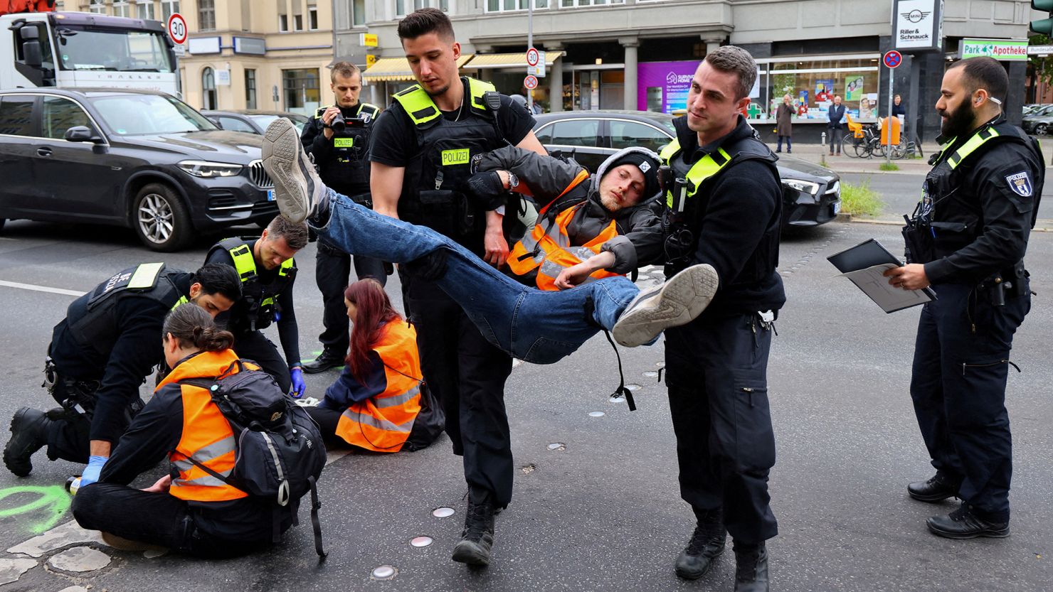 Police officers on May 16, 2023 carry away a climate activist from "Letzte Generation" (Last Generation), who had glued himself to a street in Berlin.