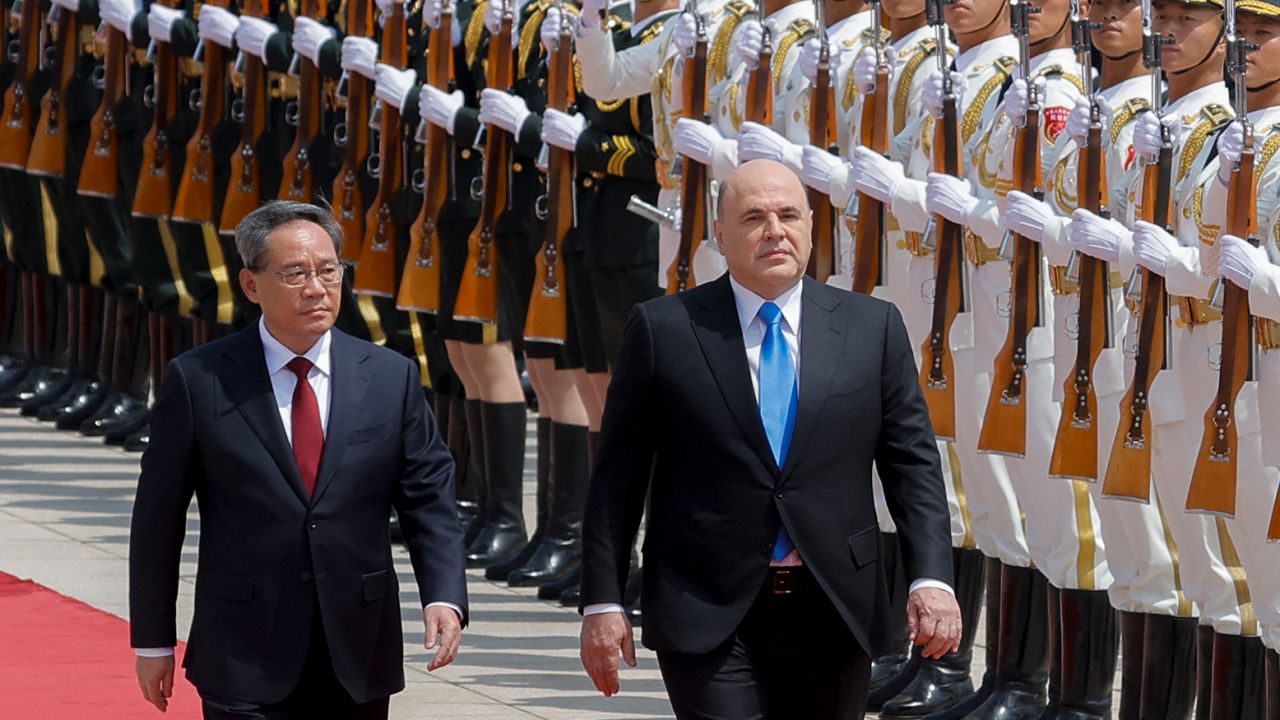 Russian Prime Minister Mikhail Mishustin and Chinese Premier Li Qiang attend a welcoming ceremony in Beijing on May 24, 2023. 