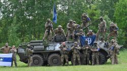 Fighters of the Russian Volunteer Corps and allied group, the Freedom of Russia Legion, stand next to a seized armoured personnel carrier during a presentation for the media in northern Ukraine, not far from the Russian border, on May 24, 2023, amid Russian military invasion on Ukraine. Russian nationals fighting on Ukraine's side on May 24 hailed as a "success" a brazen mission to send groups of volunteers across the border into southern Russia and back. Russia on May 23 said it deployed jets and artillery to fight off armed attackers who crossed into the southern region of Belgorod from Ukraine, exposing weaknesses on Moscow's frontier. (Photo by SERGEY BOBOK / AFP) (Photo by SERGEY BOBOK/AFP via Getty Images)